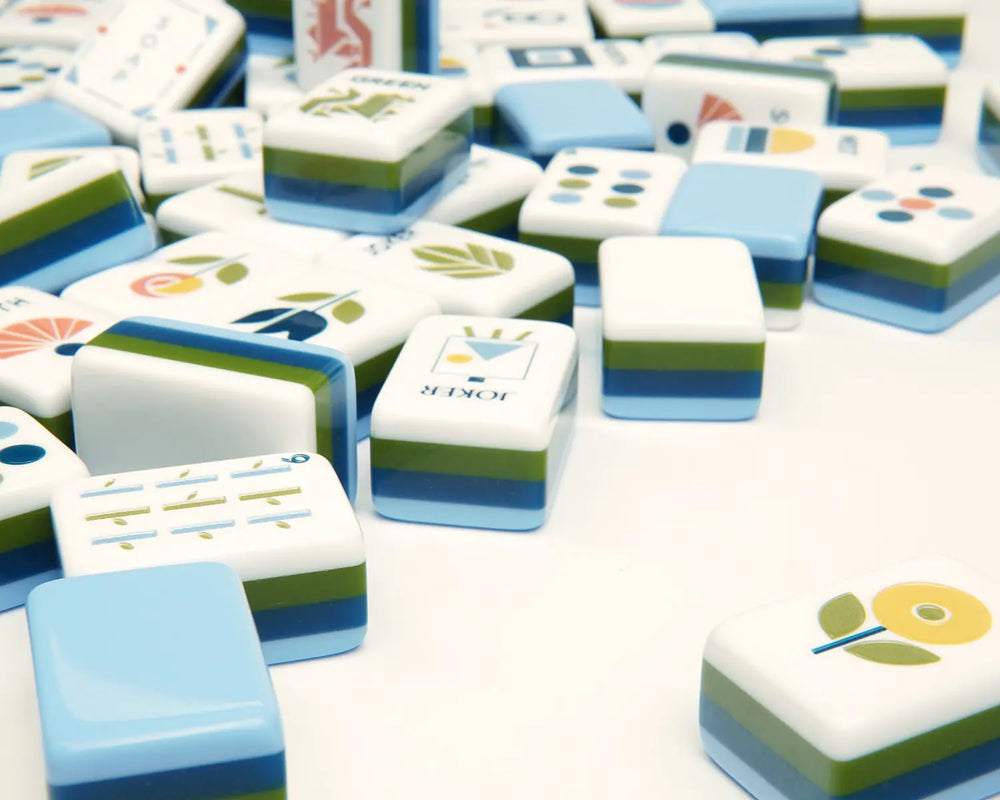 Blooming Geometry flower tile beside scattered layered American Mahjong tiles