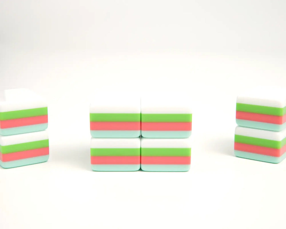Blue Manor Mahjong tiles showing seafoam backs, coral-pink and green centers, and white faces